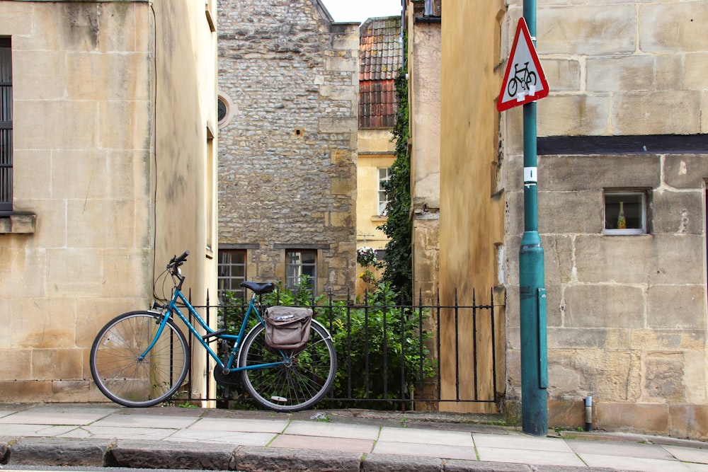 blue bike parked beside sidewalk