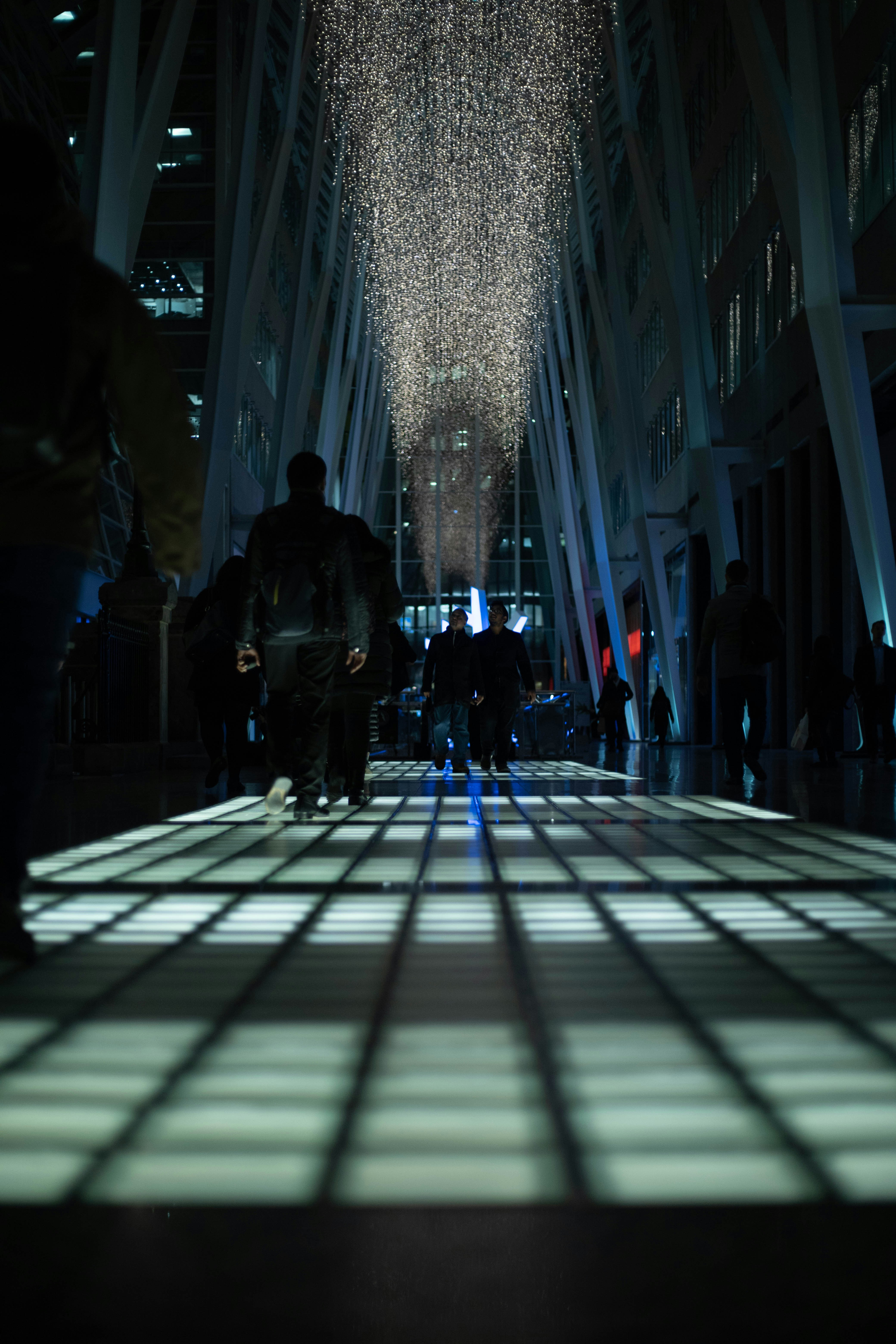 a group of people walking down a long hallway