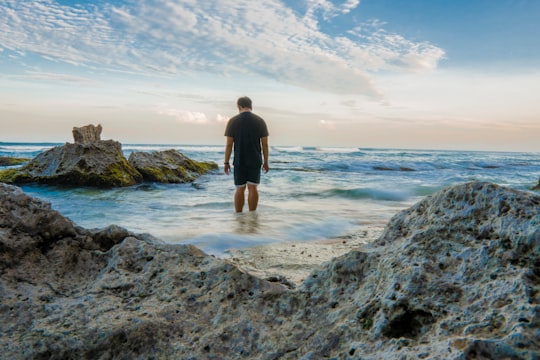 man standing on seashore near rocks in Nusa Penida Indonesia