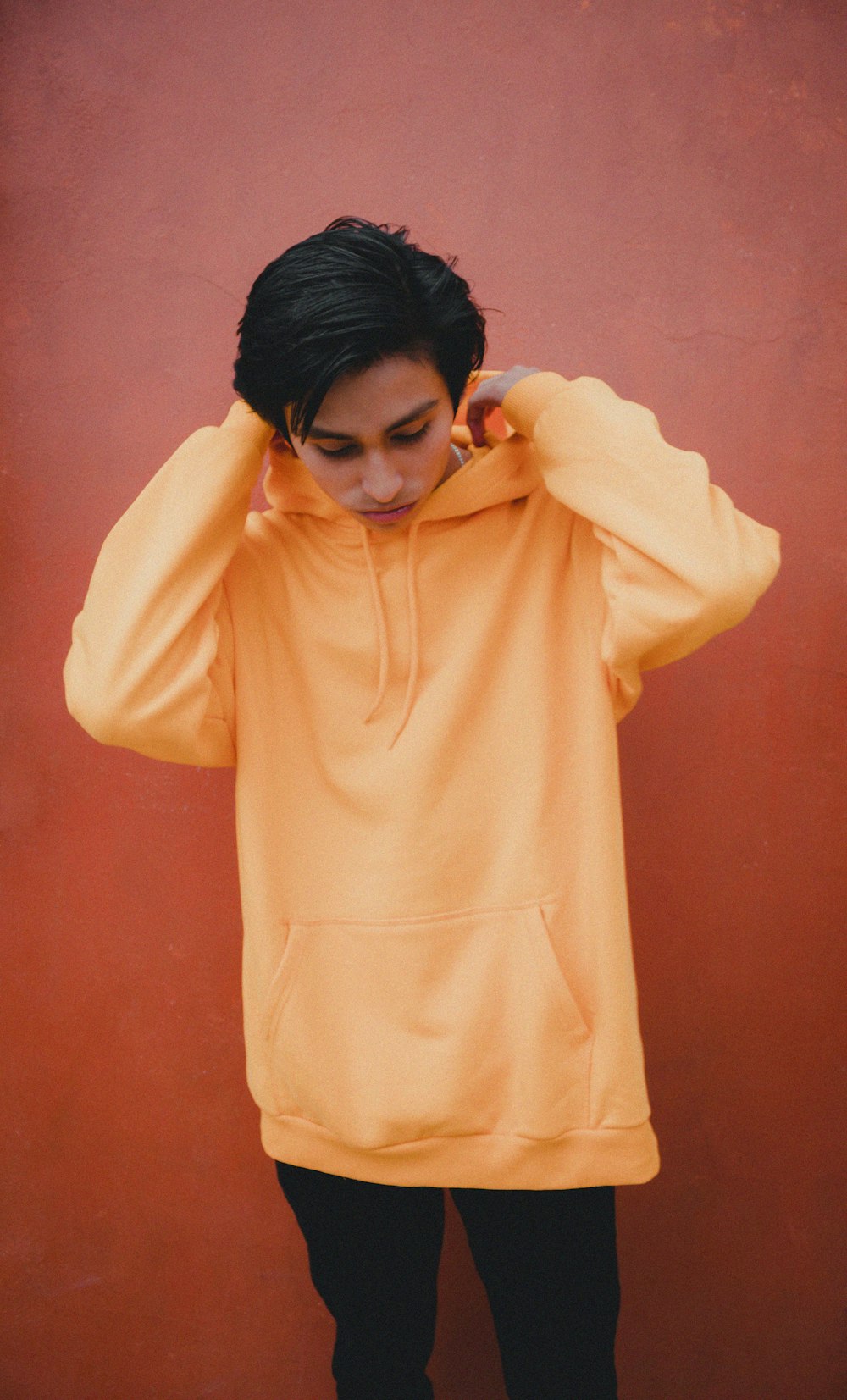 standing man in yellow pullover hoodie