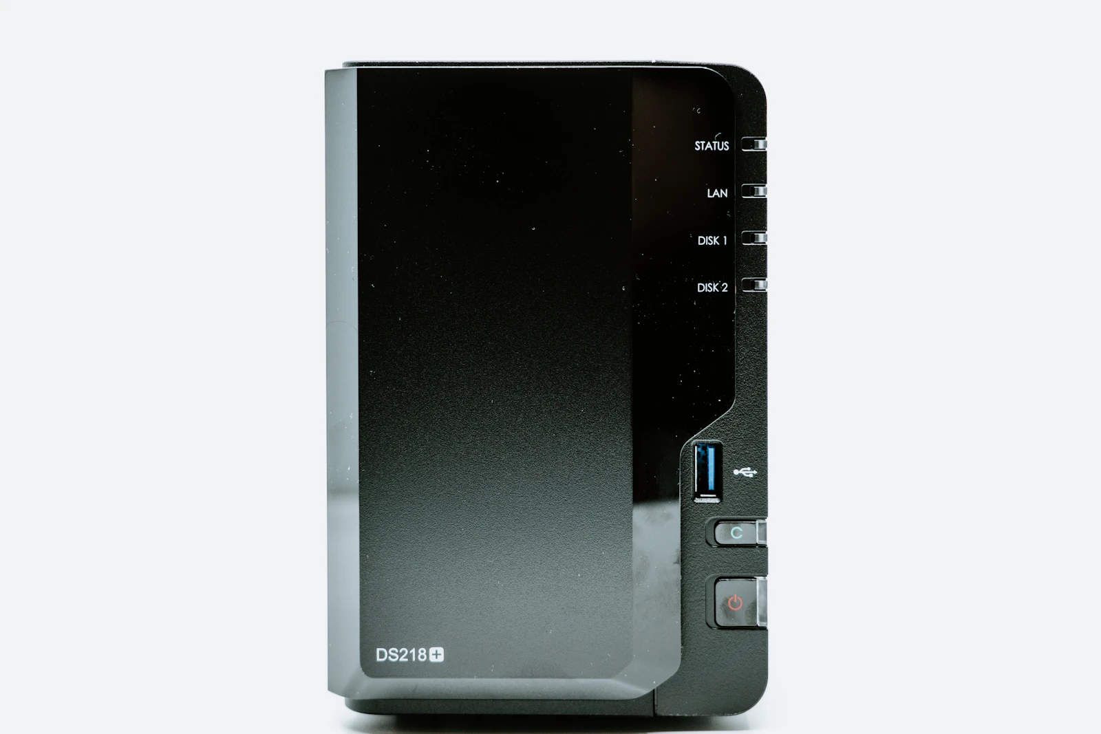 Boîtier NAS noir posé sur une surface blanche