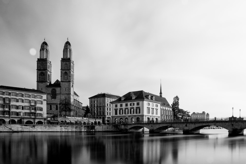 grayscale photography of a bridge leading to a cathedral building