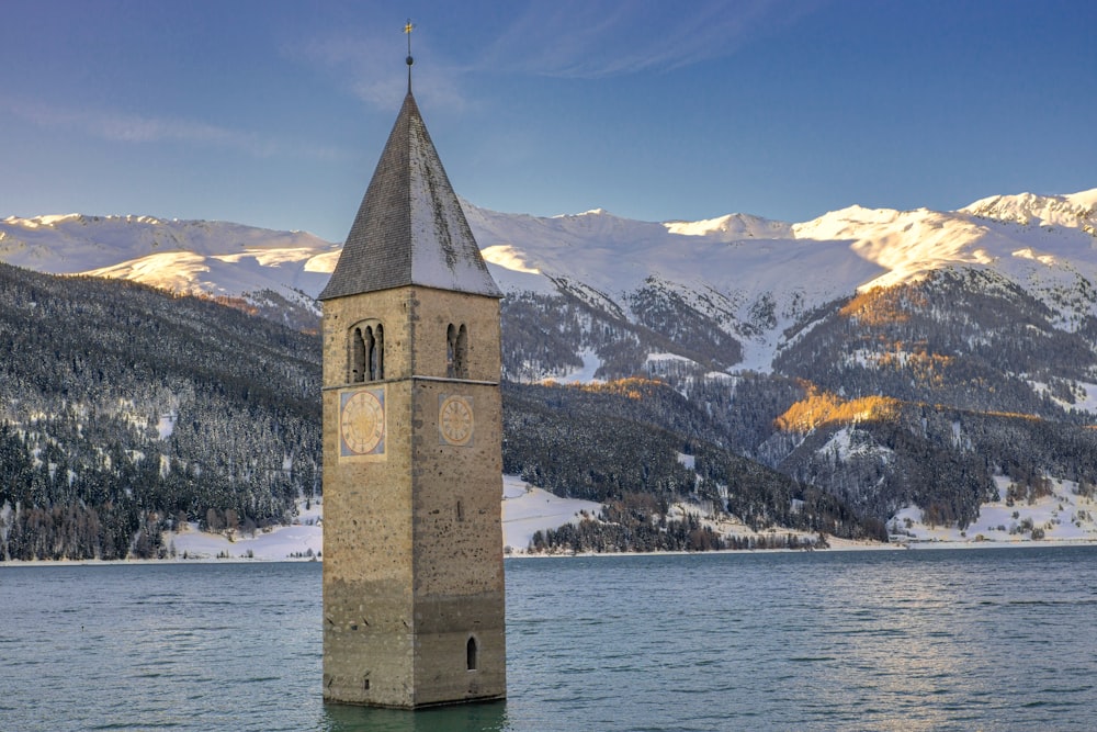 Reschensee Italia Tirol del Sur cerca del cuerpo de agua viendo la montaña bajo el cielo azul y blanco
