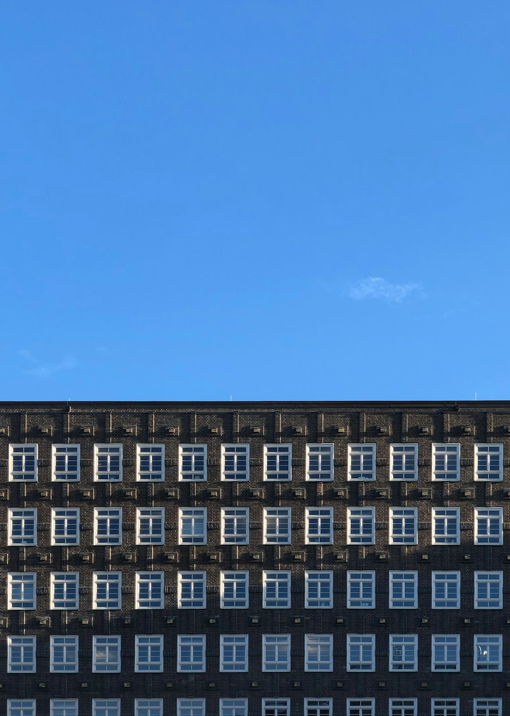 brown and white high-rise building under blue and white sky