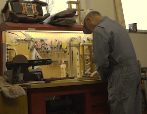 A handyman fixing a kitchen cabinet with a focused expression