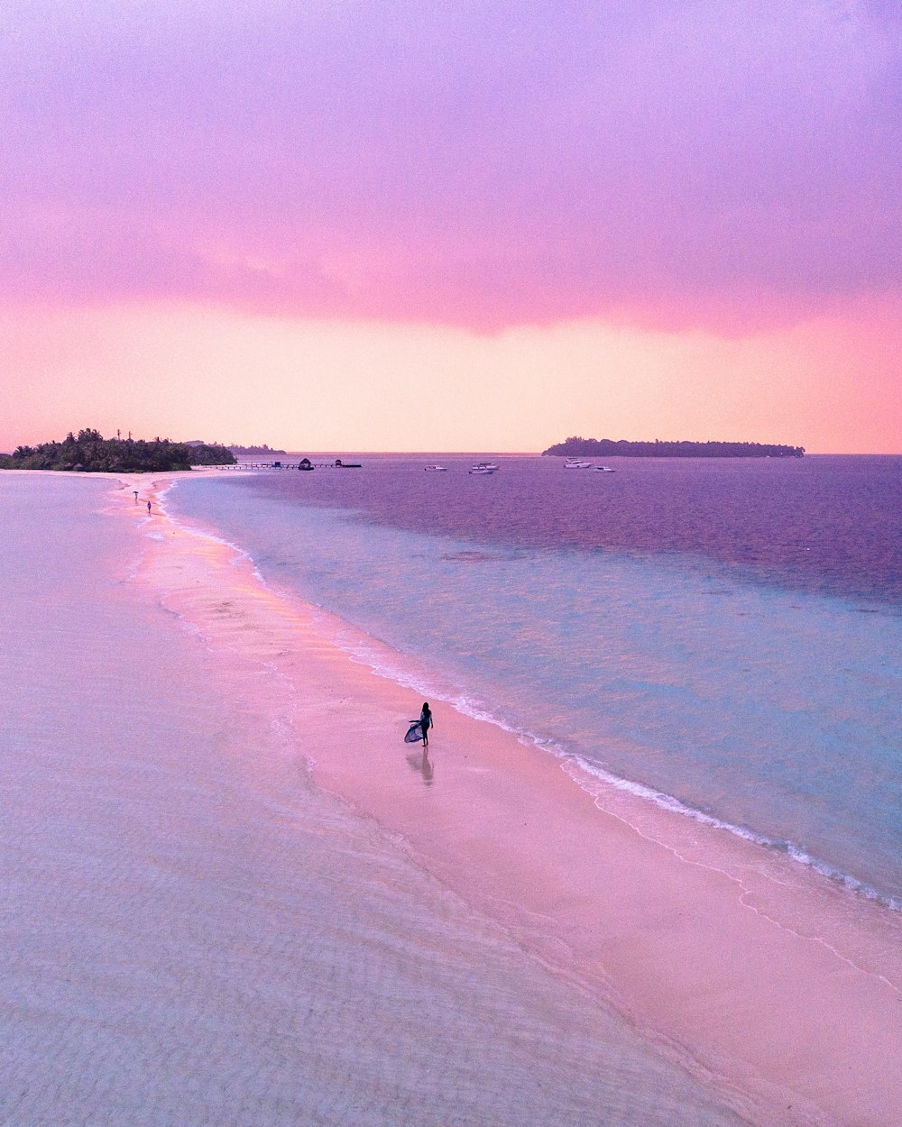 a person walking on a beach with a surfboard