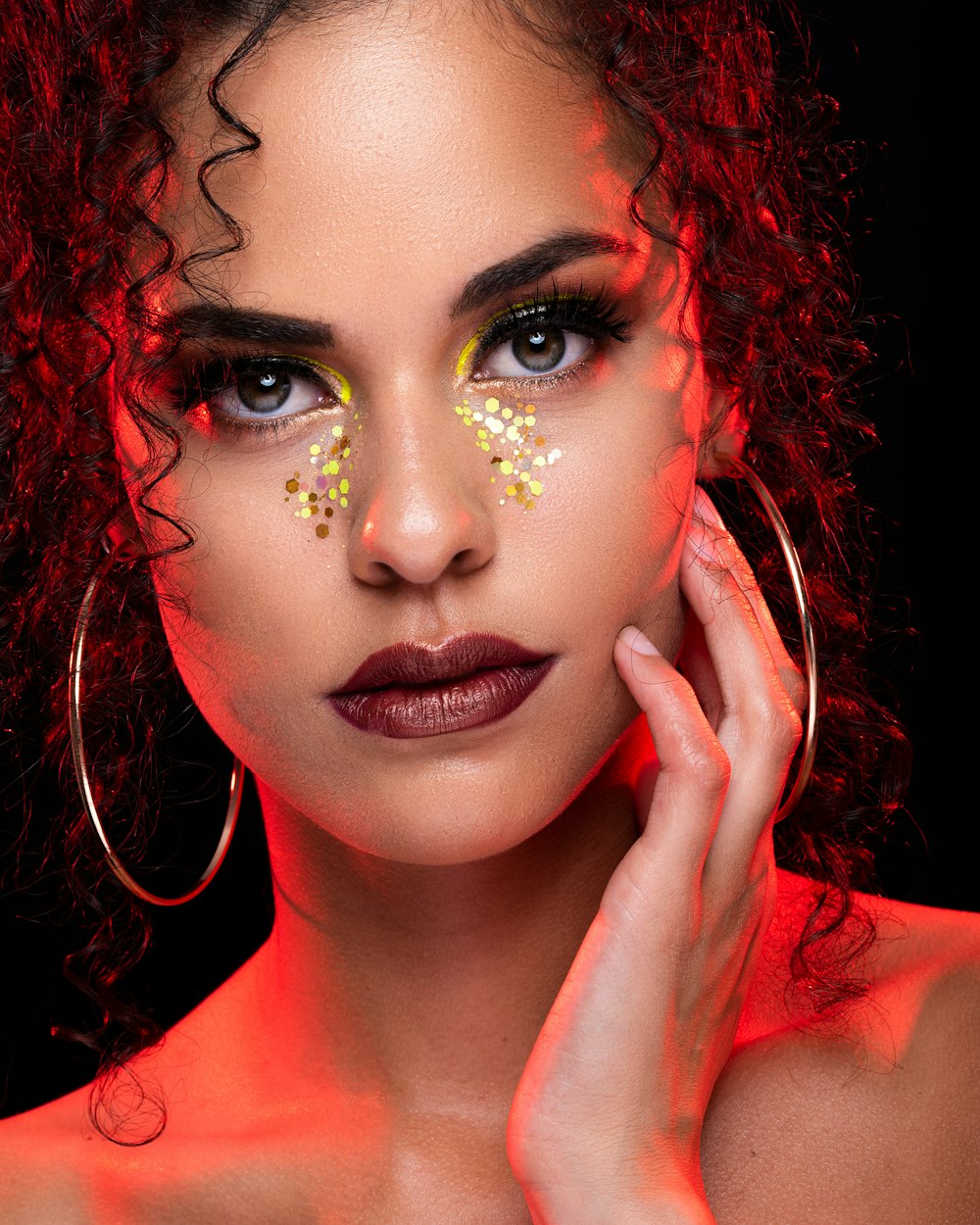 shallow focus photo of woman wearing pair of silver-colored hoop earrings