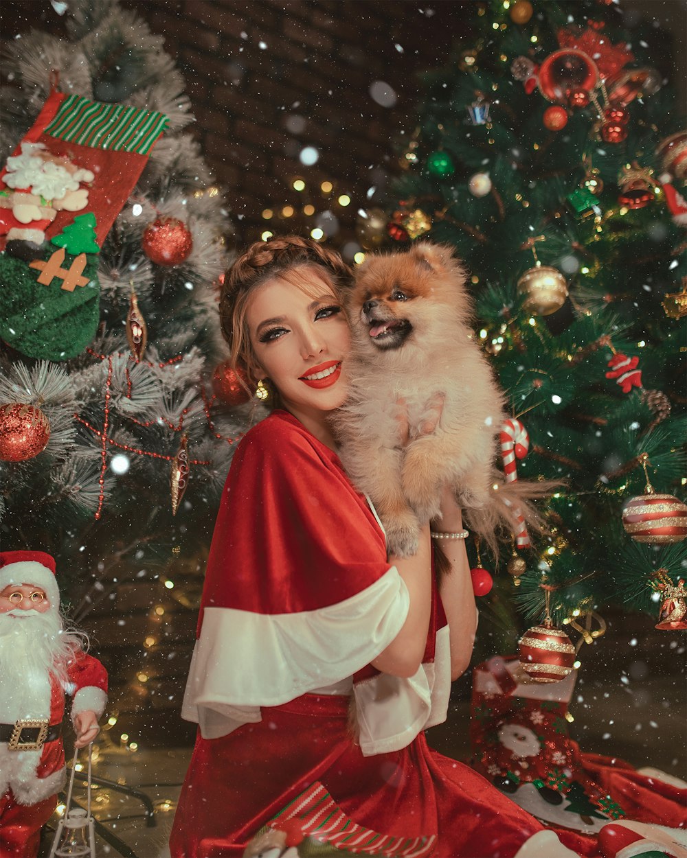 woman smiling and holding dog beside Christmas decors