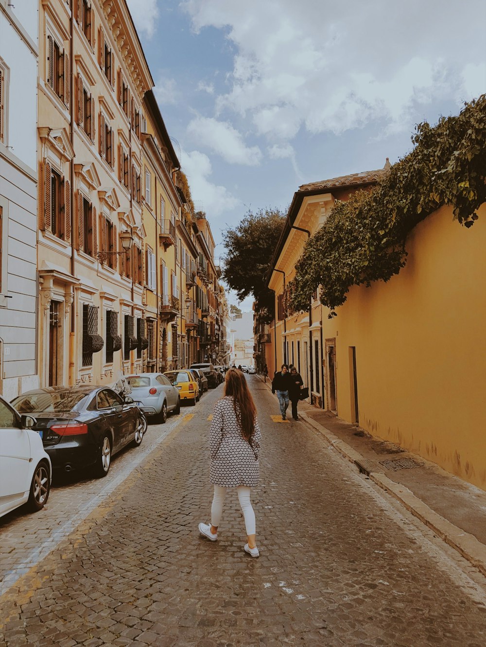 woman walking near parked cars