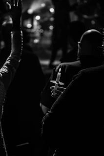 A candlelight vigil scene with flickering candles illuminating photos of children
