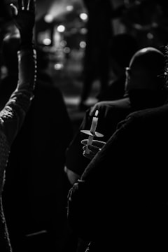 A serene candlelit vigil with people holding hands in unity.