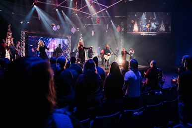 a group of people sitting on a stage in front of a crowd