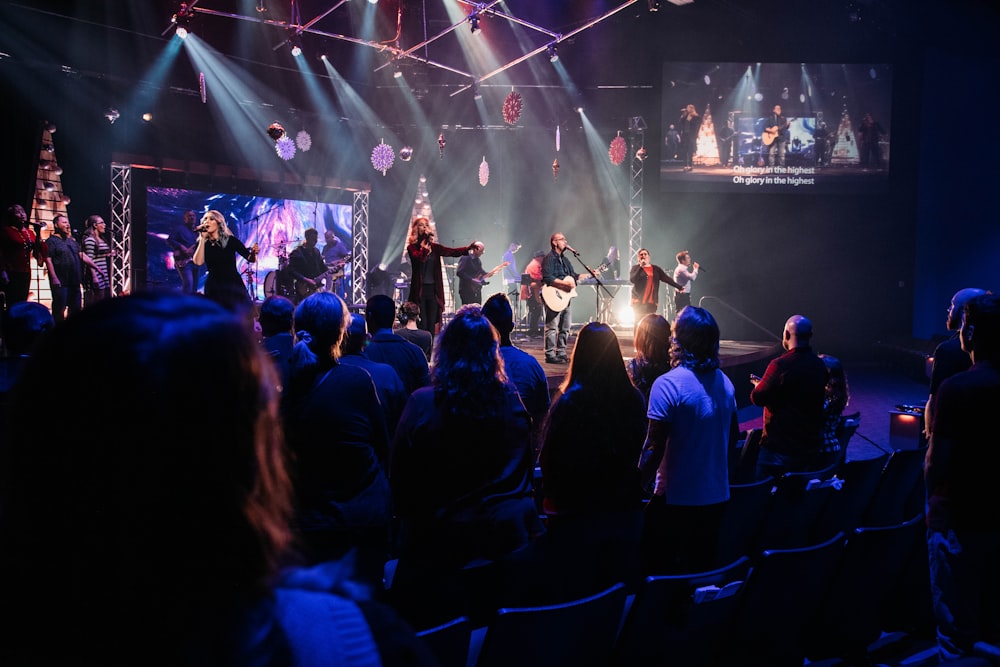 a group of people sitting on a stage in front of a crowd