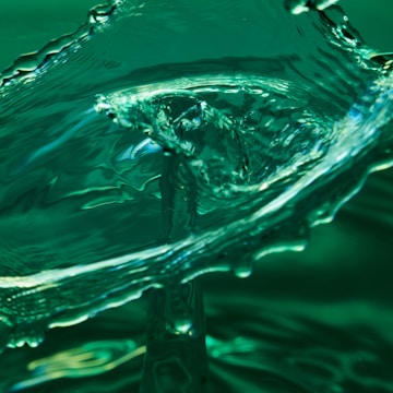 A dynamic splash of water captured in mid-air with intricate details and smooth curves. The fluid motion conveys a sense of energy and elegance.