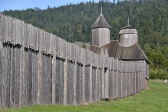 A fortified base with survivors working on defenses under a dark green sky.