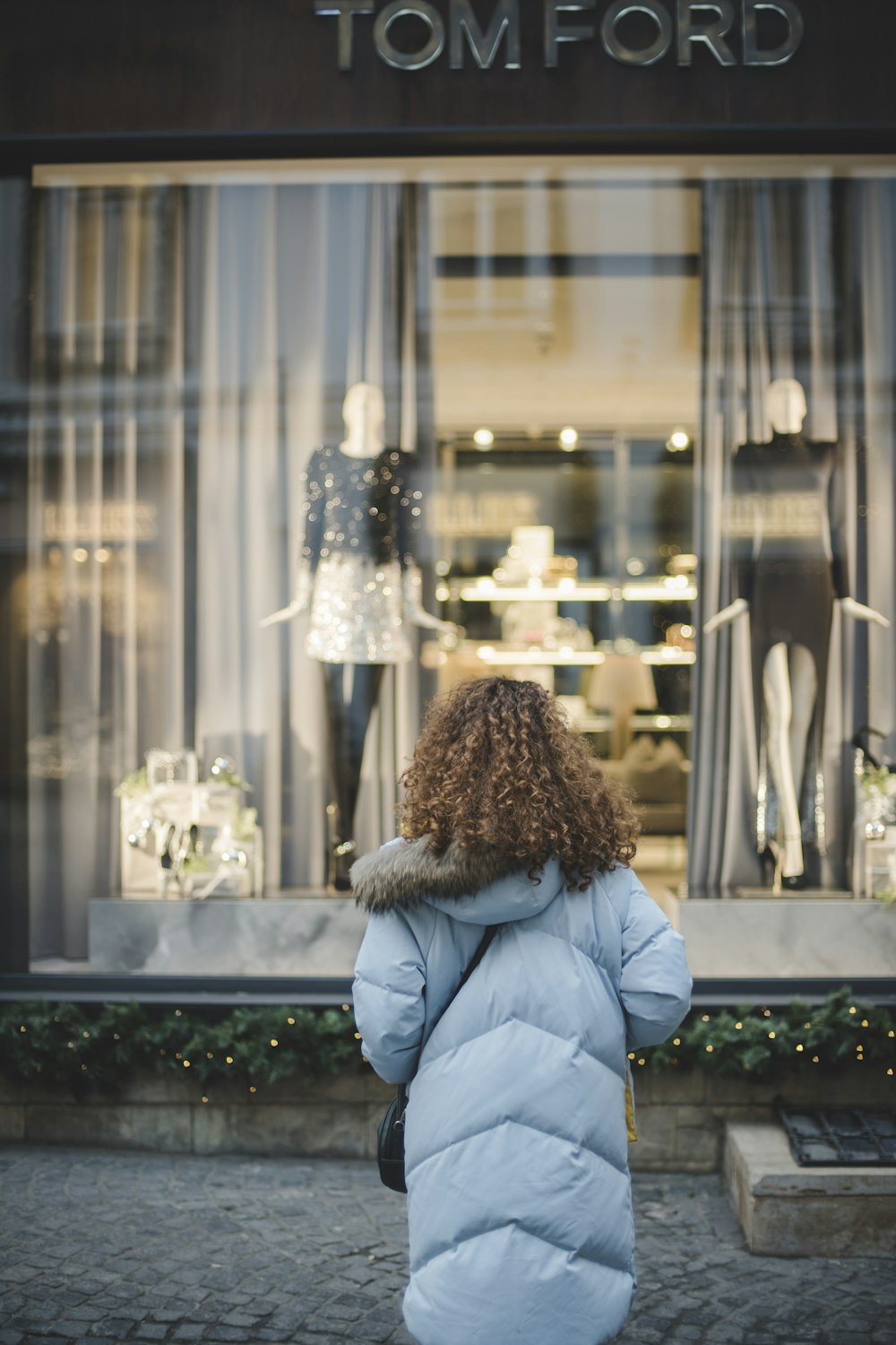 Mujer mirando los maniquíes dentro de la tienda