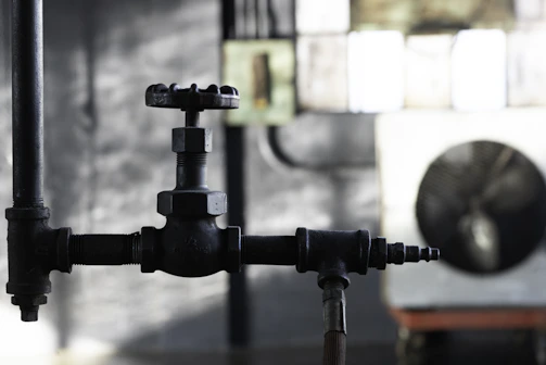 Close-up of a stainless steel gate valve with precise machining details under bright industrial lighting.
