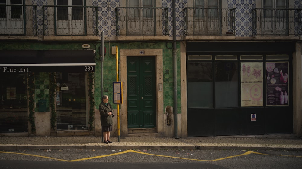 mulher em pé ao lado do edifício durante o dia