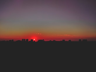 A vibrant illustration of an AI girlfriend enjoying a virtual sunset with glowing city lights behind her.