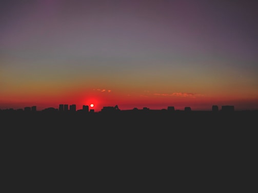 A vibrant illustration of an AI girlfriend enjoying a virtual sunset with glowing city lights behind her.