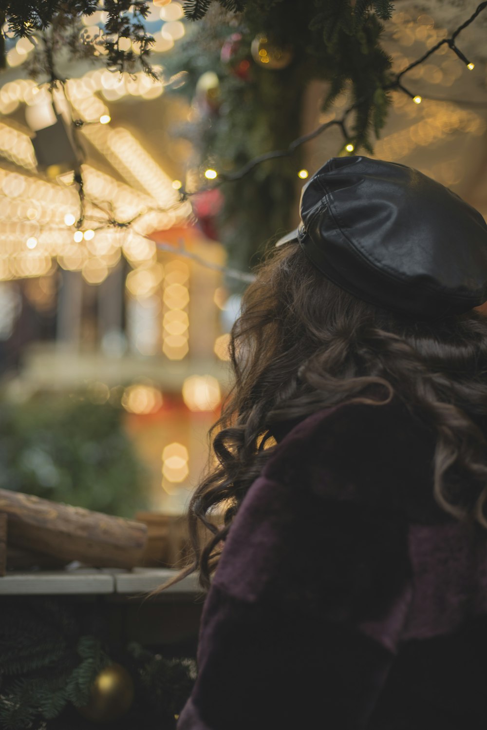 woman wearing black cap near mini string lights