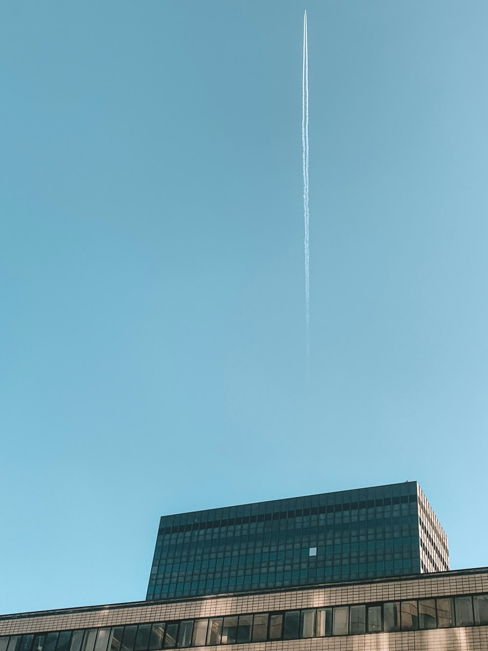 contrail above gray building