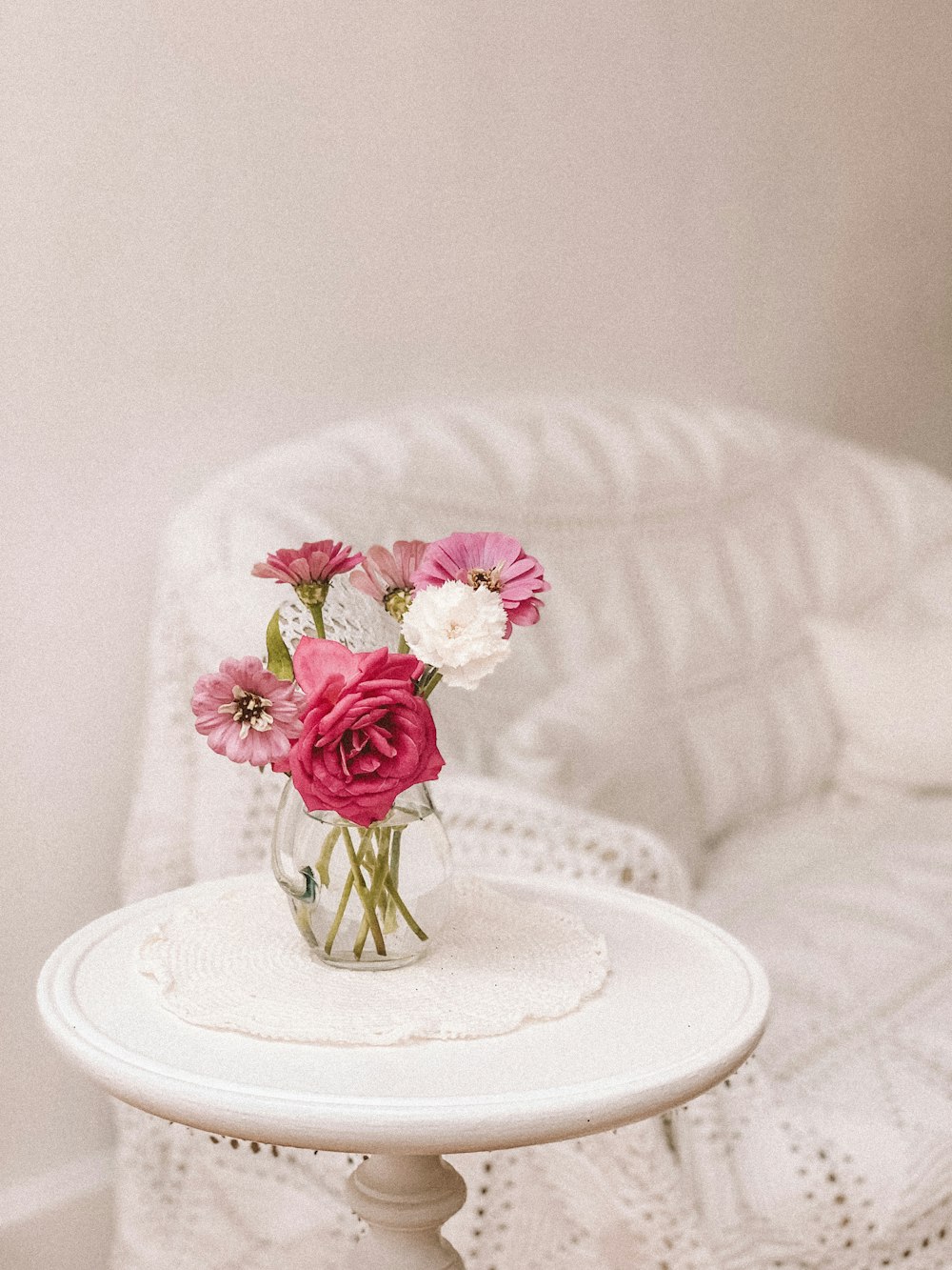 pink and white flowers in vase on end table