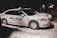 Two white taxis are parked on a snowy street at night. The vehicles have the name 'Bluebird Stephenville' written on the sides in blue lettering, with the numbers 9 and 1 visible. The scene is dimly lit, with a few lights visible in the background.