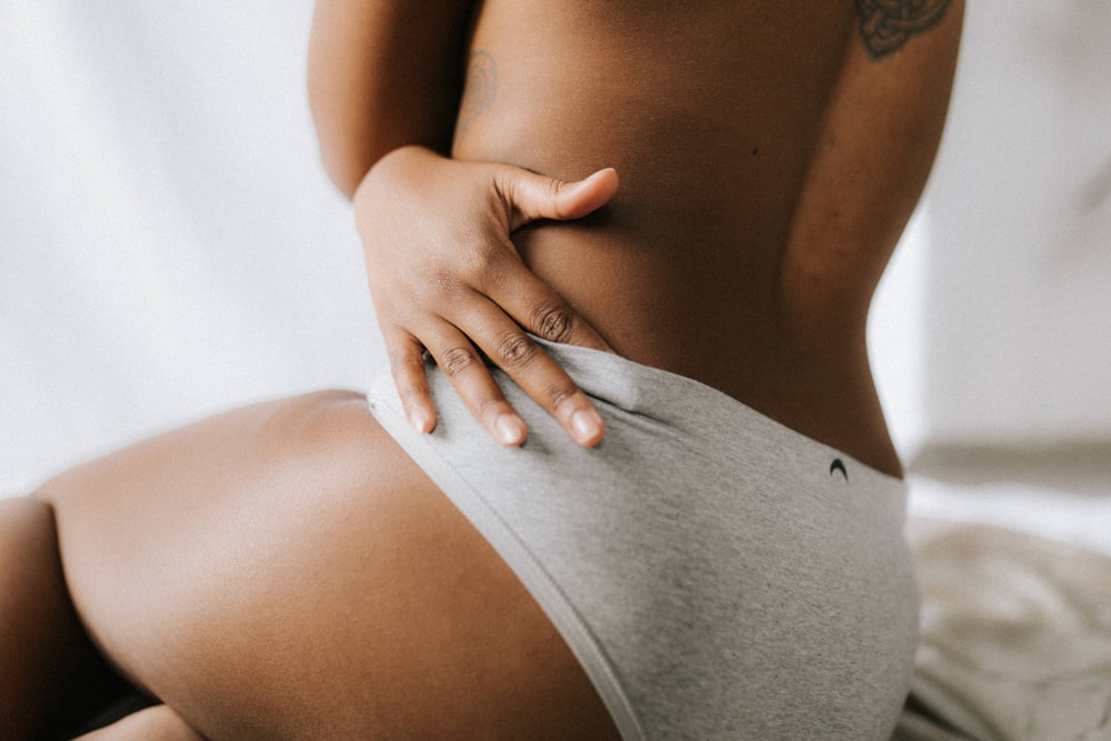 topless person wearing gray underwear sitting