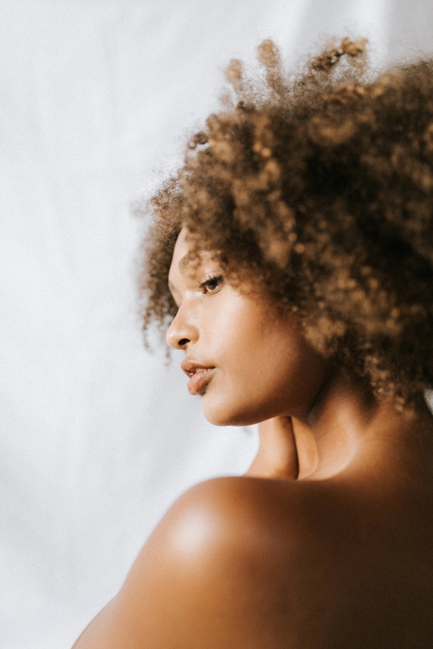 Close-up beauty portrait of a woman with clear, even-toned facial skin in soft natural light, representing the skin-clarity goals of melasma treatment