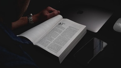A focused individual using a tablet to read a productivity ebook in a bright workspace.