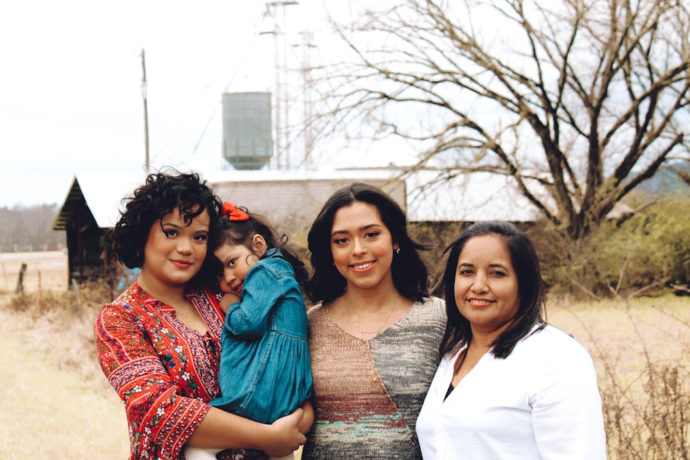 three women and one toddler girl looking at the camera