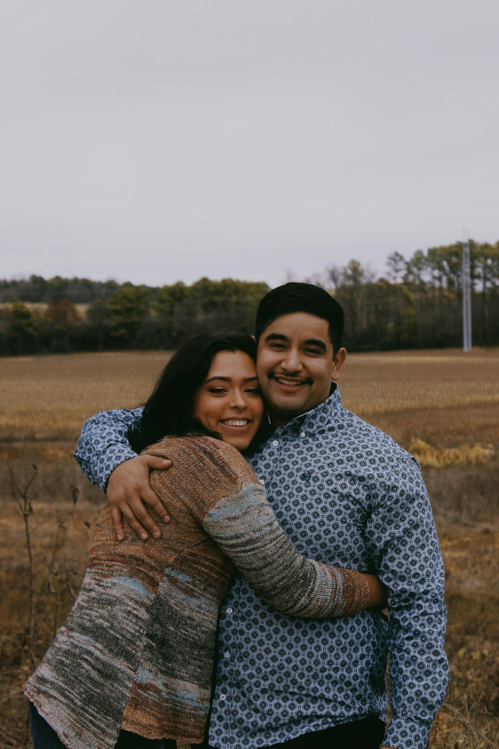 woman smiling and hugging smiling man during day
