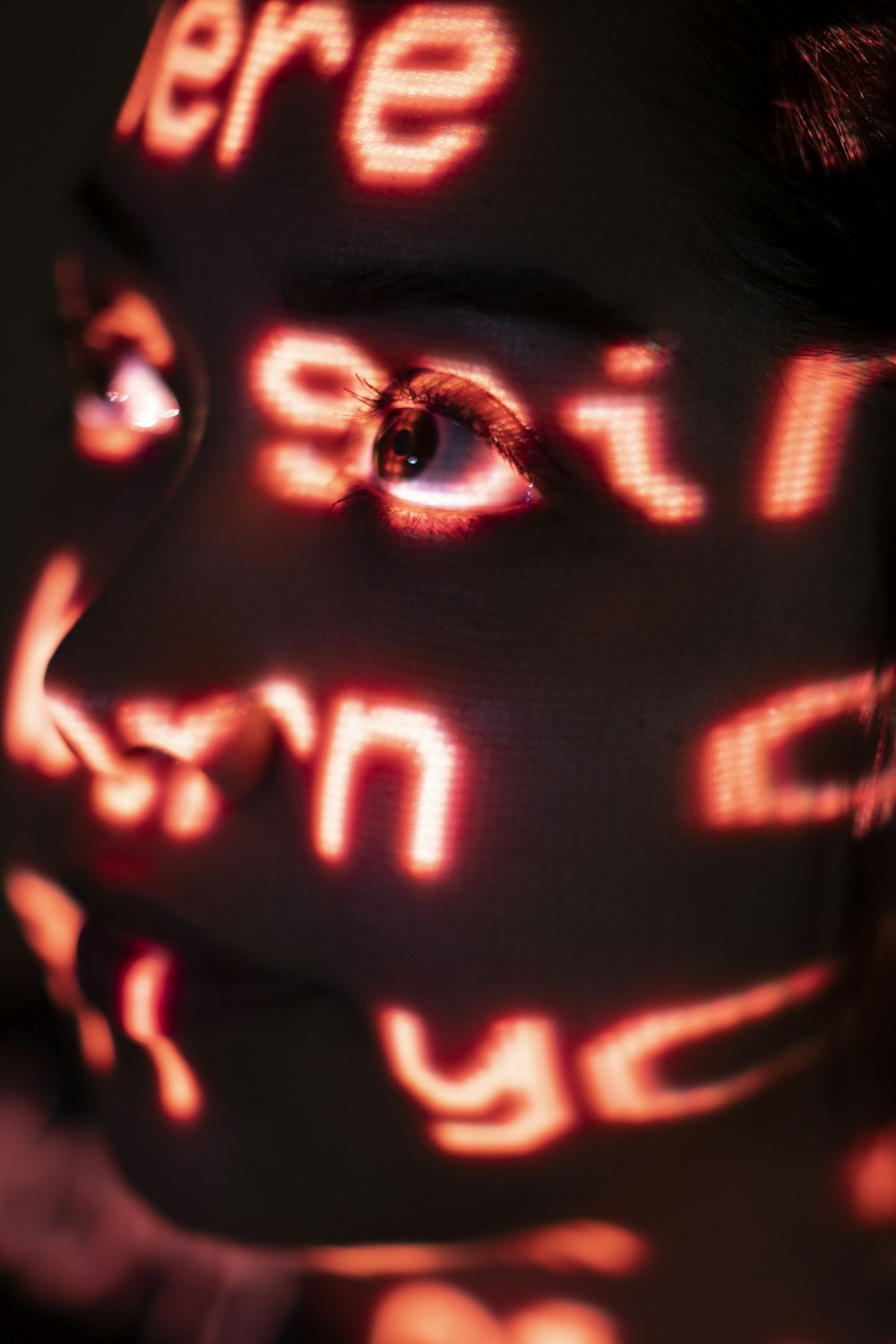 a woman's face with glowing words projected on it