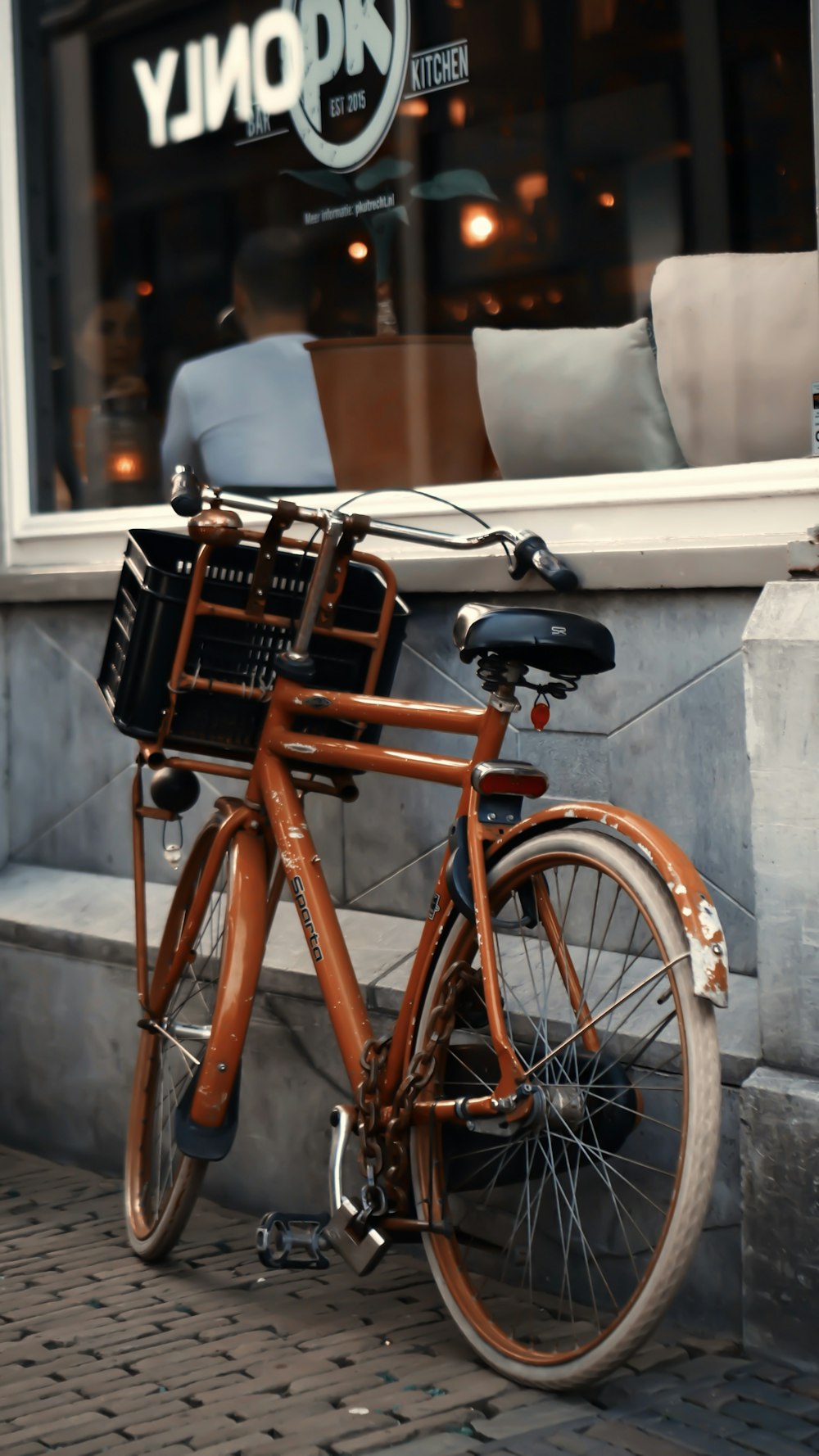 parked orange bike beside shop