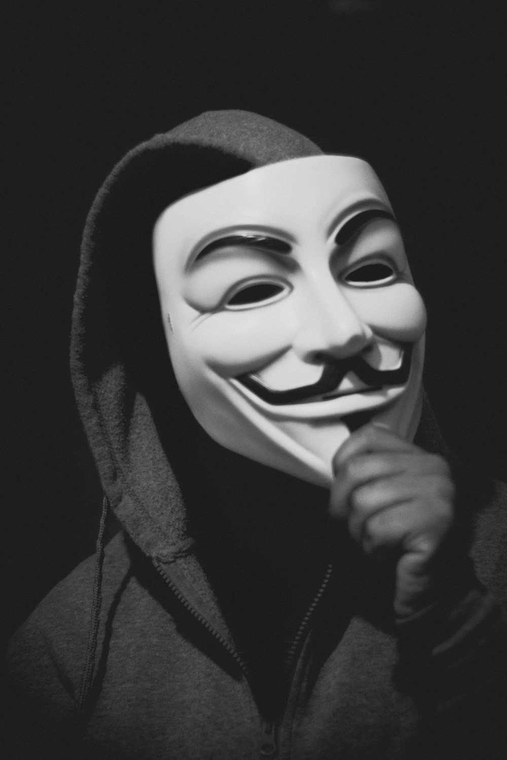 persona che tiene la maschera di Guy Fawkes