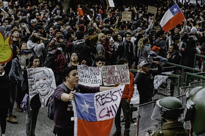 Young Cuban leaders engaged in a lively outdoor workshop session in Santiago de Chile, surrounded by notebooks and flags.