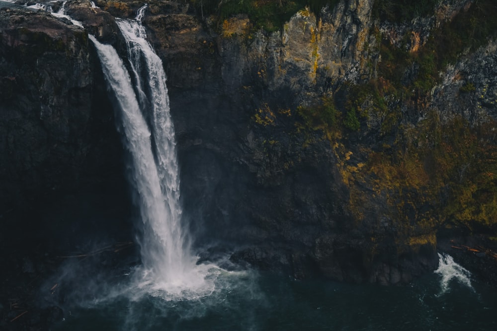 waterfalls on cliff near mountain