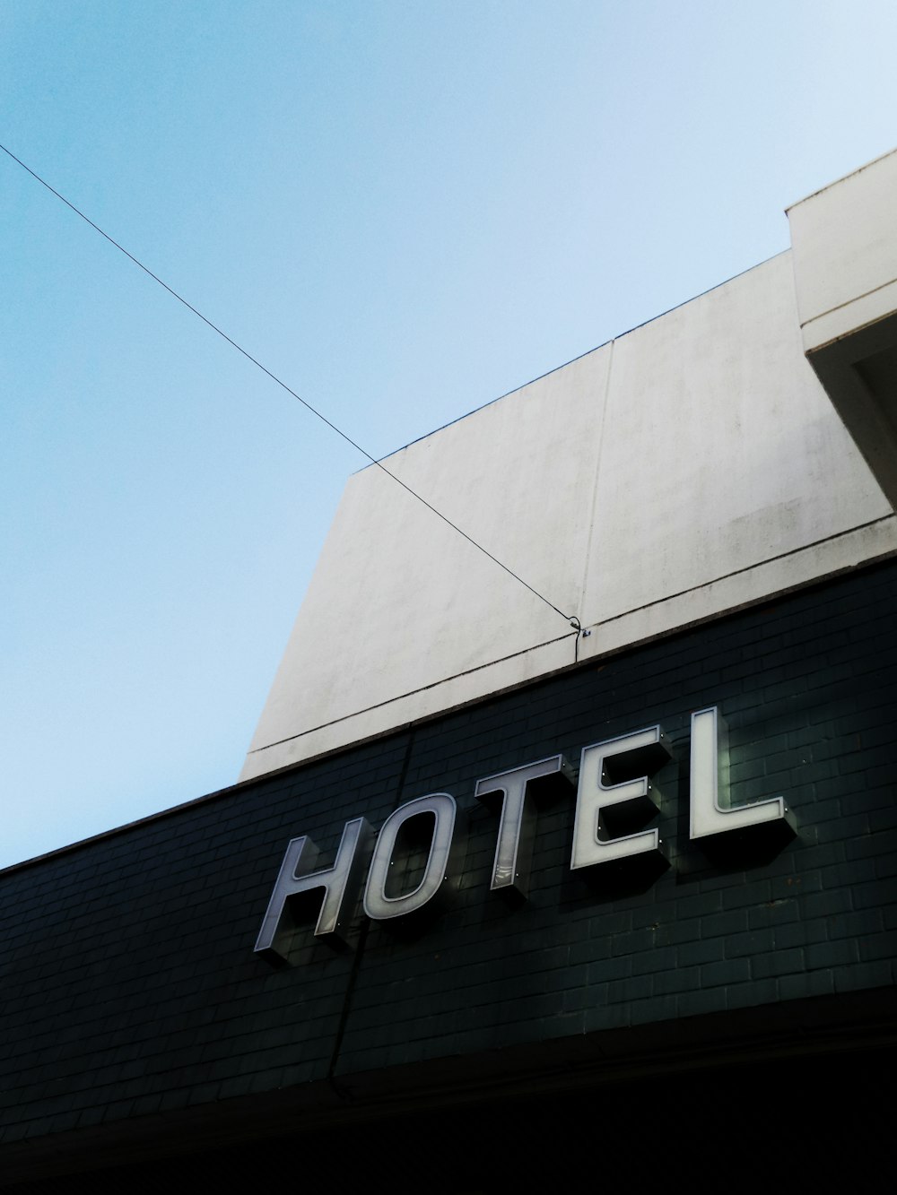 穏やかな青空に浮かぶ黒と白のコンクリート製ホテルの建物