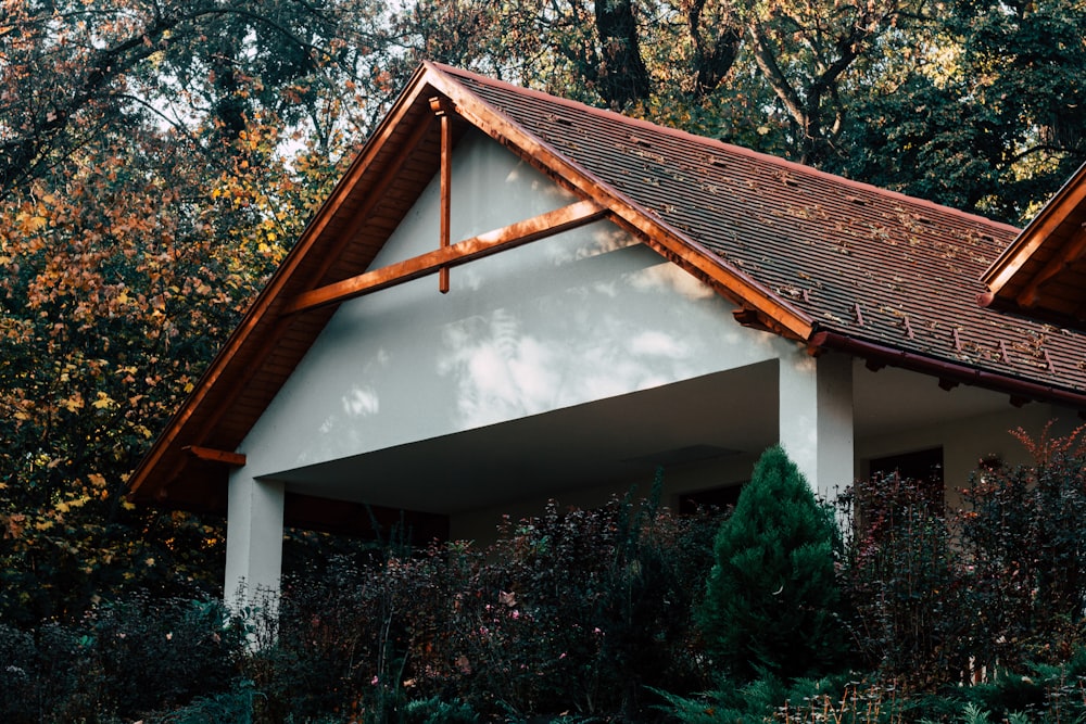 white and brown house surrounded with trees