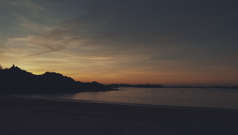 silhouette of sea cliff during golden hour