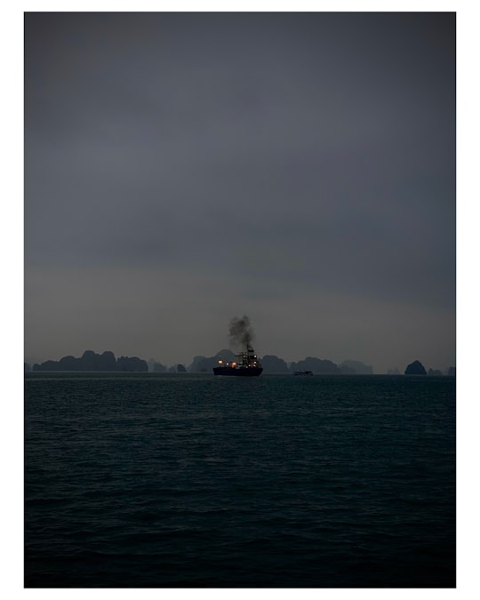 ship in sea under gray sky in Ha Long Bay Vietnam
