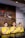 Three individuals are standing behind a reception desk, each wearing a yellow uniform. They are smiling and have their right hands placed over their chests. The background features a wooden wall with part of a logo and the word 'SEMARNG' visible.