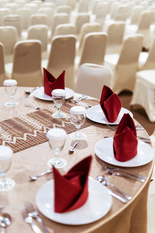 Close-up of round tables with crisp linens and comfortable chairs arranged for a social gathering.