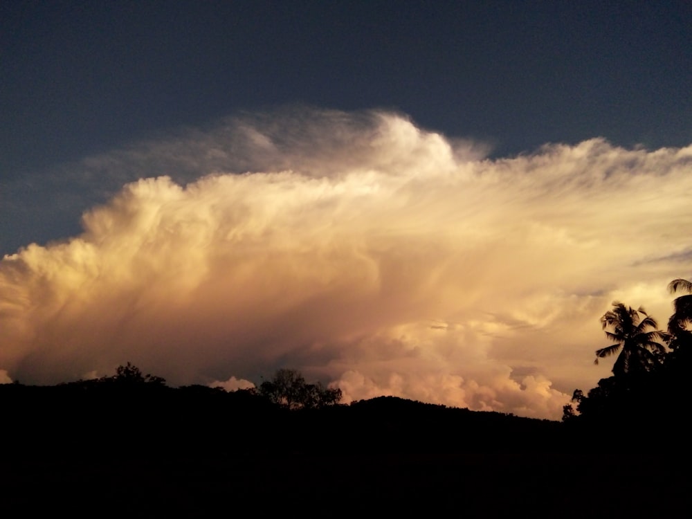 silhouette photography of land under a cloudy sky during daytime