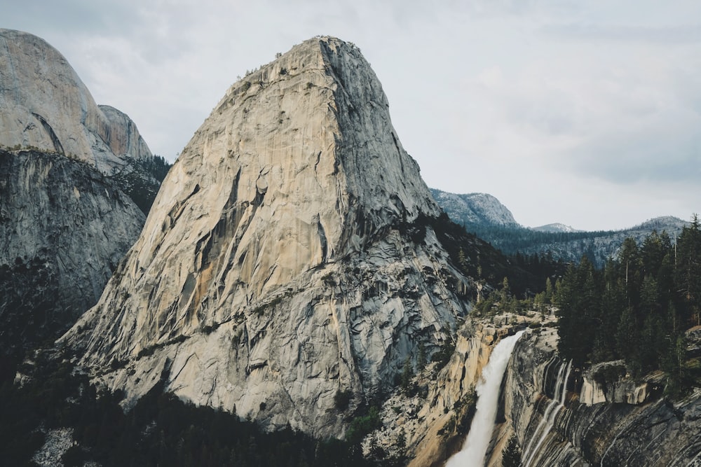 aerial photography of false flowing in the mountain during daytime