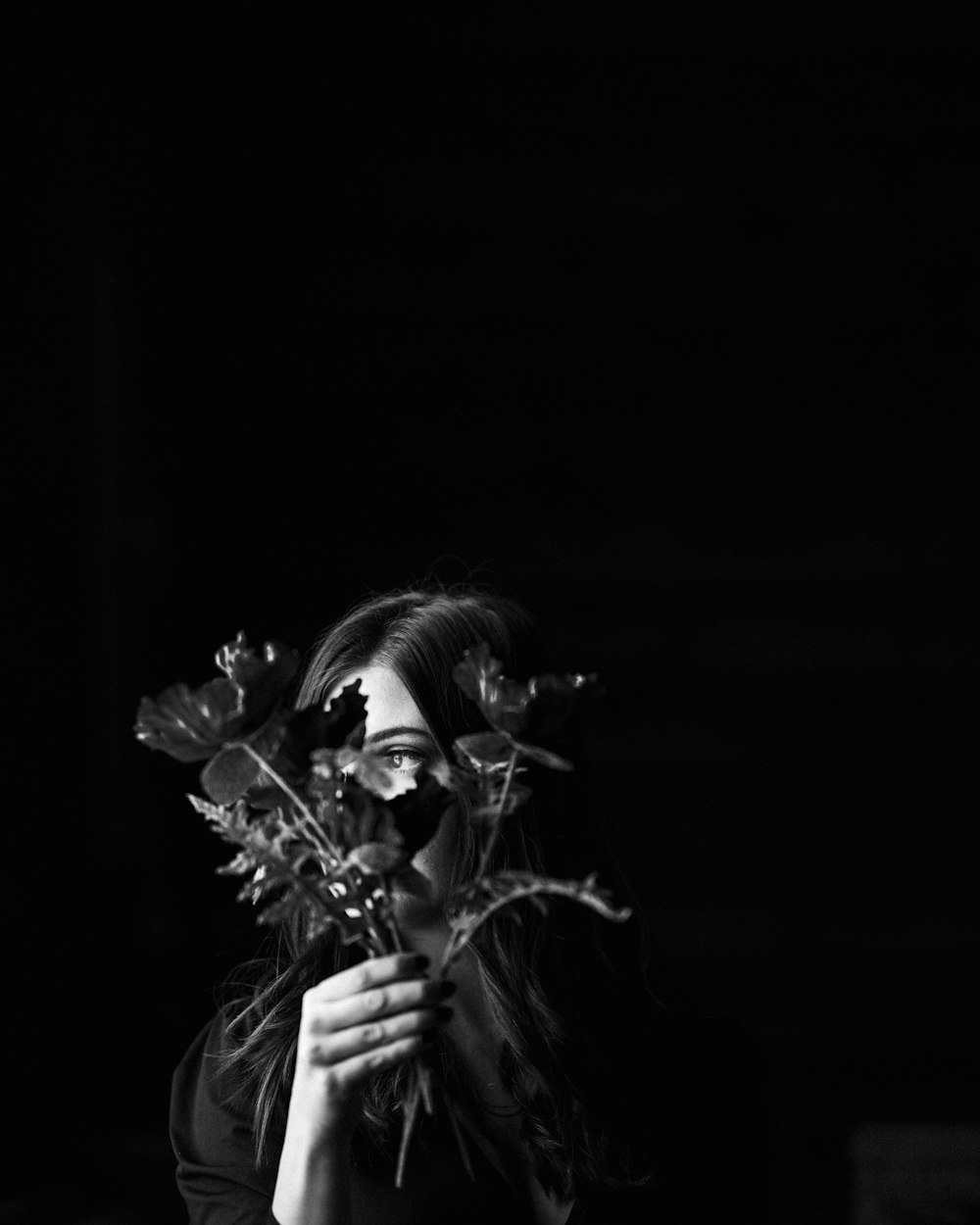 grayscale photo of woman holding roses