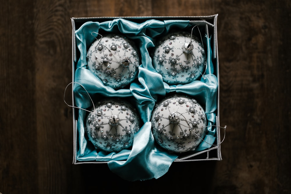 four white-and-gray floral baubles in box