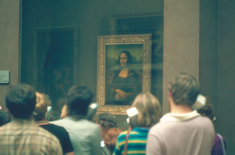 pessoas em pé na frente da pintura de Mona Lisa