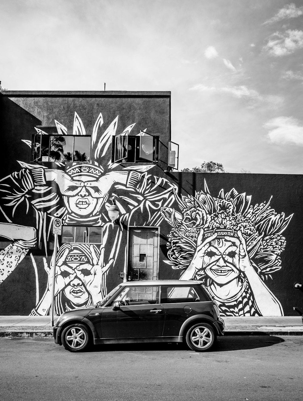 parked car near building with murals